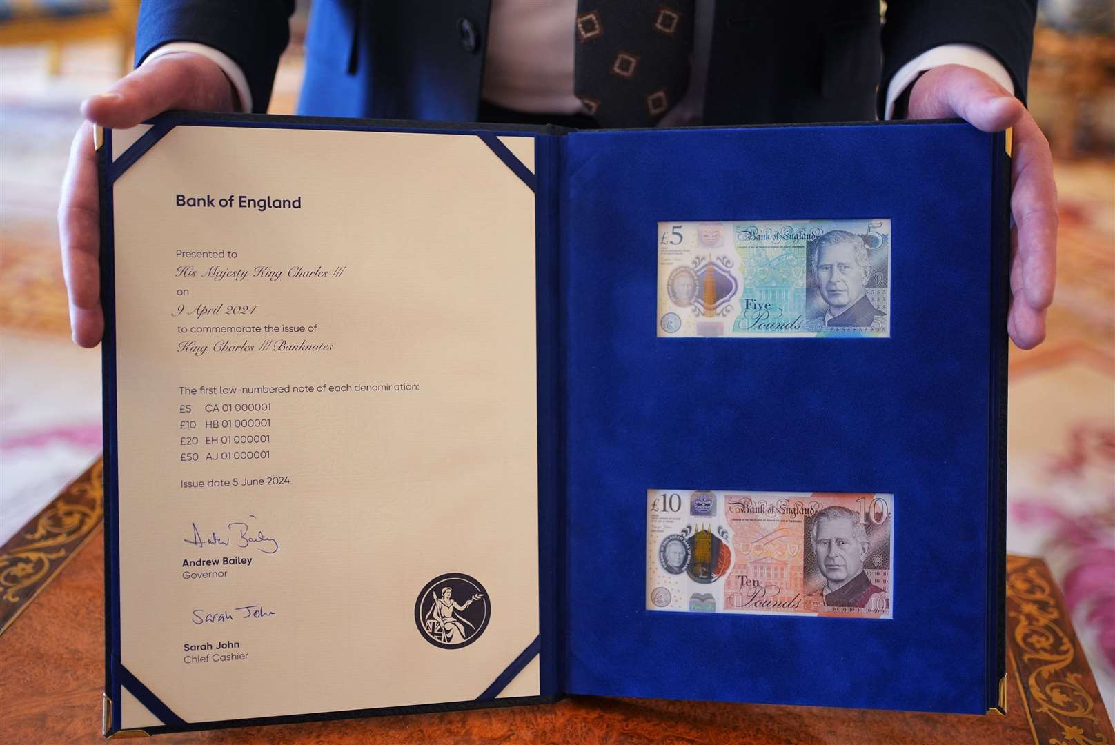 The £5 and £10 bank notes bearing the King’s portrait in a special presentation book (Yui Mok/PA)