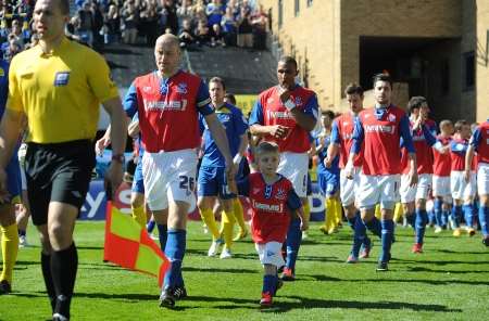 With the League 2 title within their grasp, Adam Barrett leads out Gillingham for the match against AFC Wimbledon