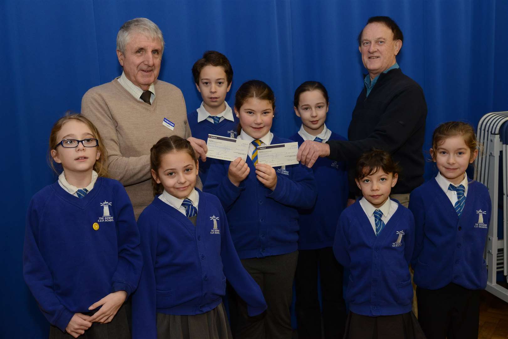Emily Sole and pupils from The Downs present cheque to David Fagg from Kent and Surrey Air Ambulance and school governor Paul Henderson