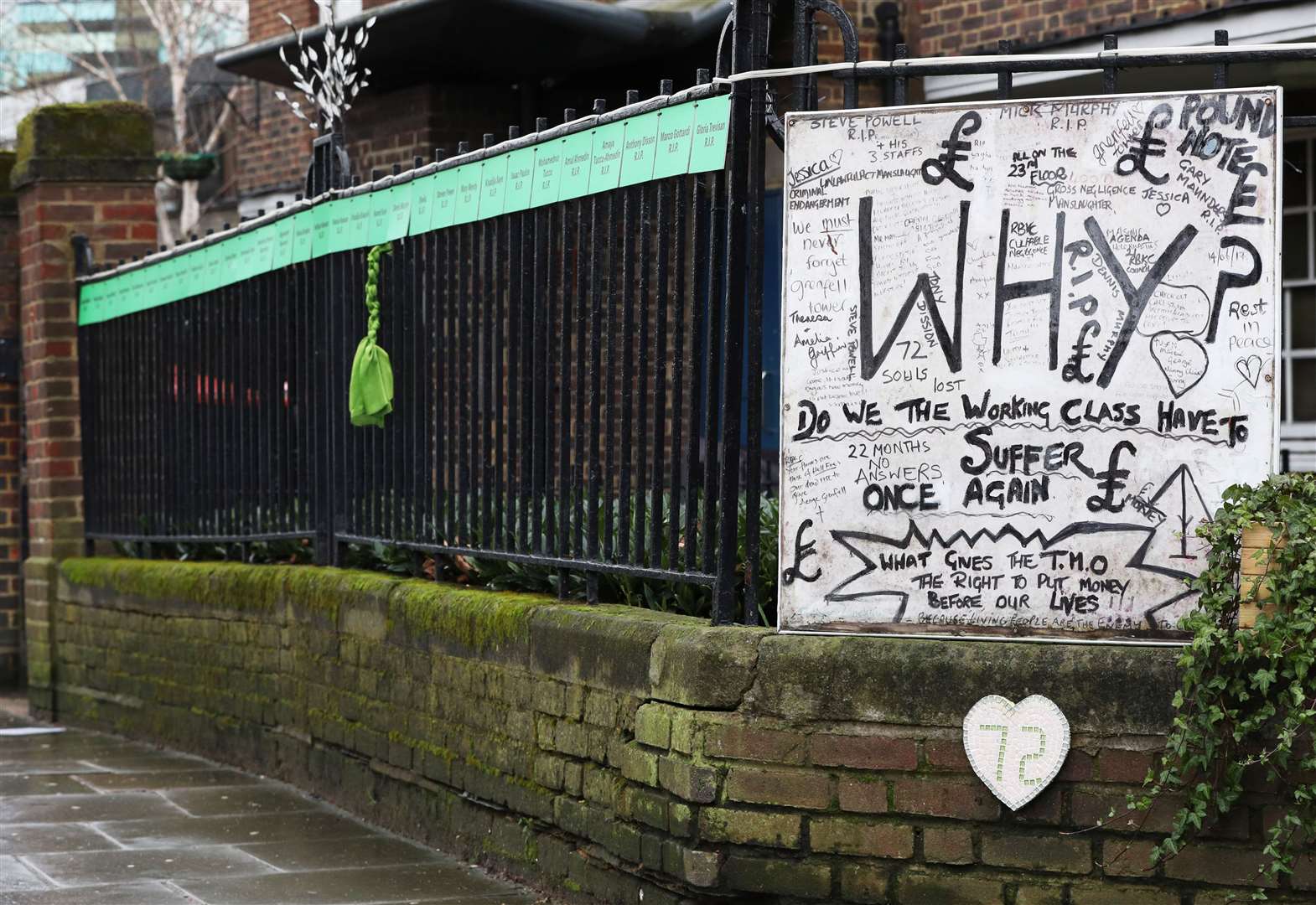 A piece of green ribbon hangs from a railing in Silchester Road which bears the names of the victims of the fire (Jonathan Brady/PA