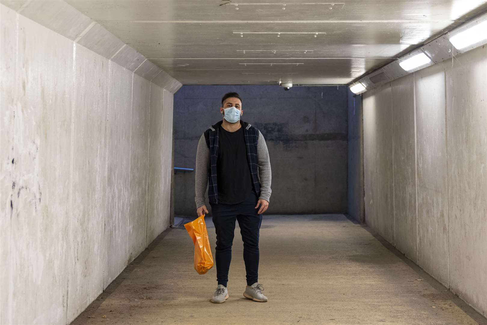 A man wearing a mask as he walks through an underpass. Picture: Jo Court