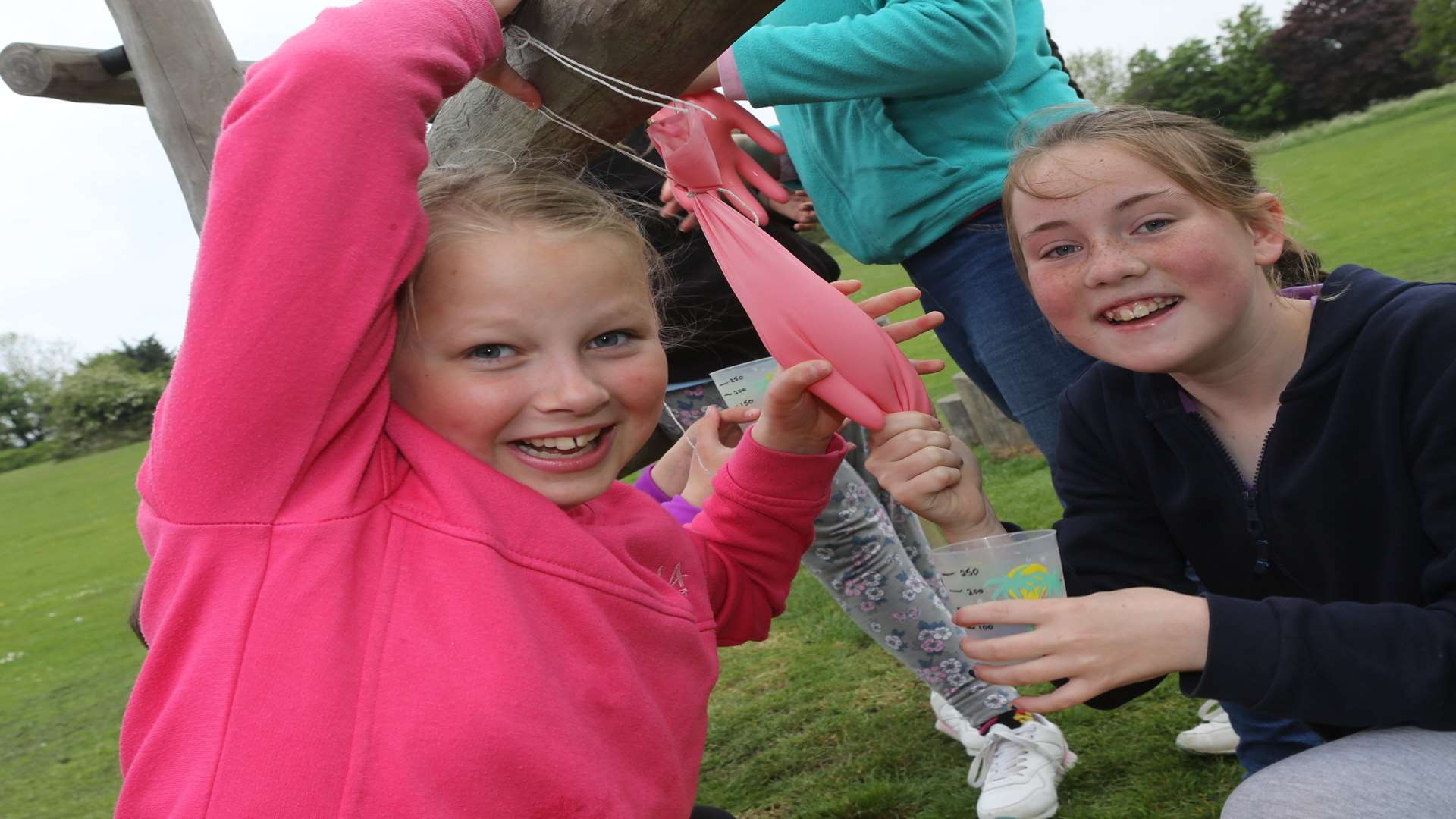 Lauren and Holly, both 11 from 2nd Minster take part in "Milking a Cow" exercise, using a latex glove filled with water for a badge collecting at The Glen in Minster