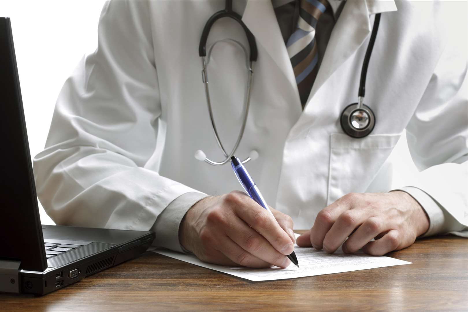 Doctor writing patient notes on a medical examination or prescription (5217371)