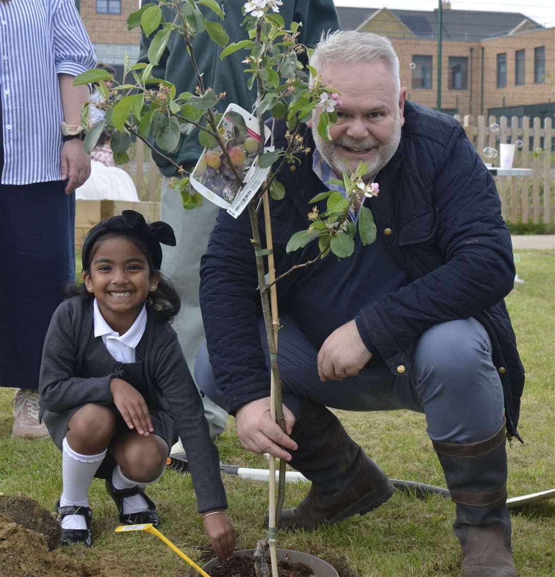 Pupil, Dhiya, and Kevin McGeough (EDC) with a tree donated by EDC. Photo credit: Poppy Webster