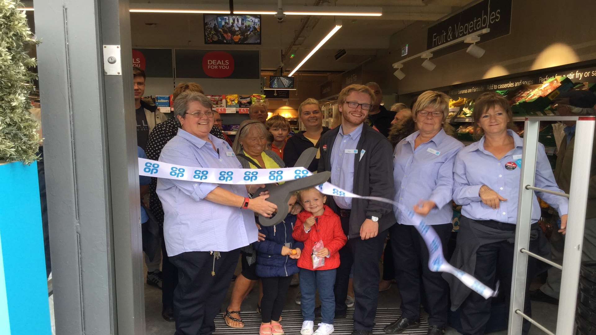 Co-op store manager Wendy Topping with colleagues and customers as she cuts the ribbon at the refurbished Aylesham branch. Picture: Co-operative Group