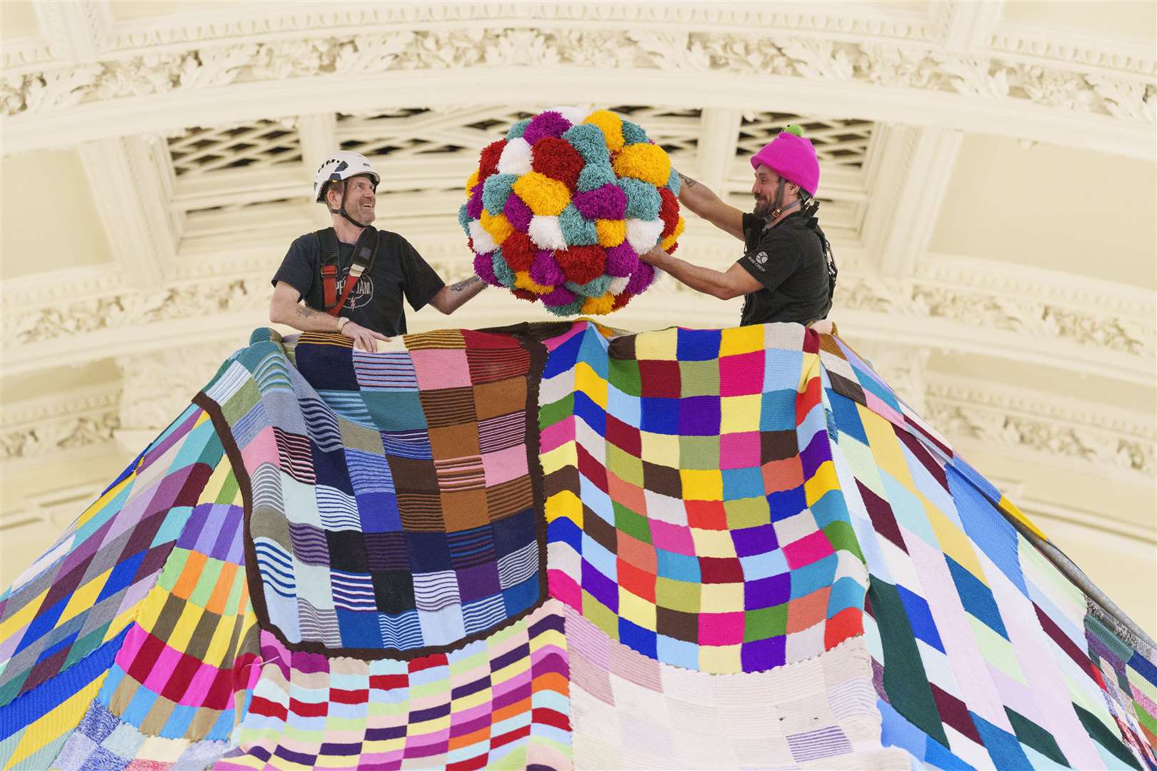 Workers place a giant bobble on top of a 23 foot high bobble hat (Dominic Lipinski/PA)