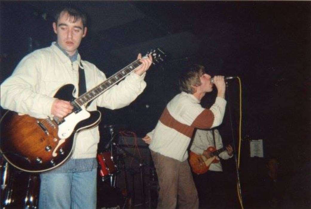 Bonehead in the foreground, with Liam Gallagher and Noel (hidden) at the Forum in Tunbridge Wells in 1994
