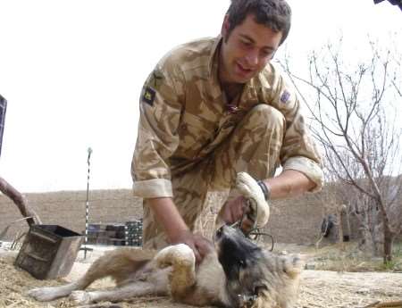 Lt Giles Walsh plays with the regiment's pet Tigger.