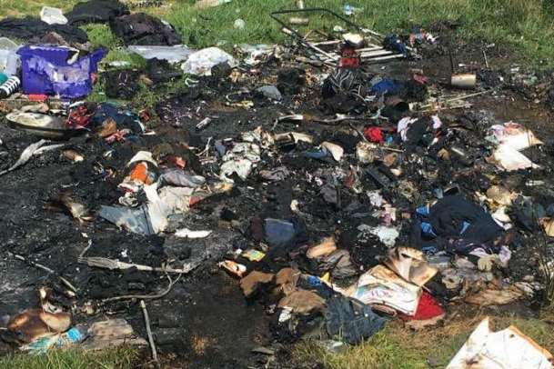 The belongings of homeless people scattered across the grass after the fire. Credit: Neil Charlick