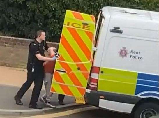 Officers attempt to put the man into the back of a police van in Luton Road, Chatham. Pic: Jade Ferguson