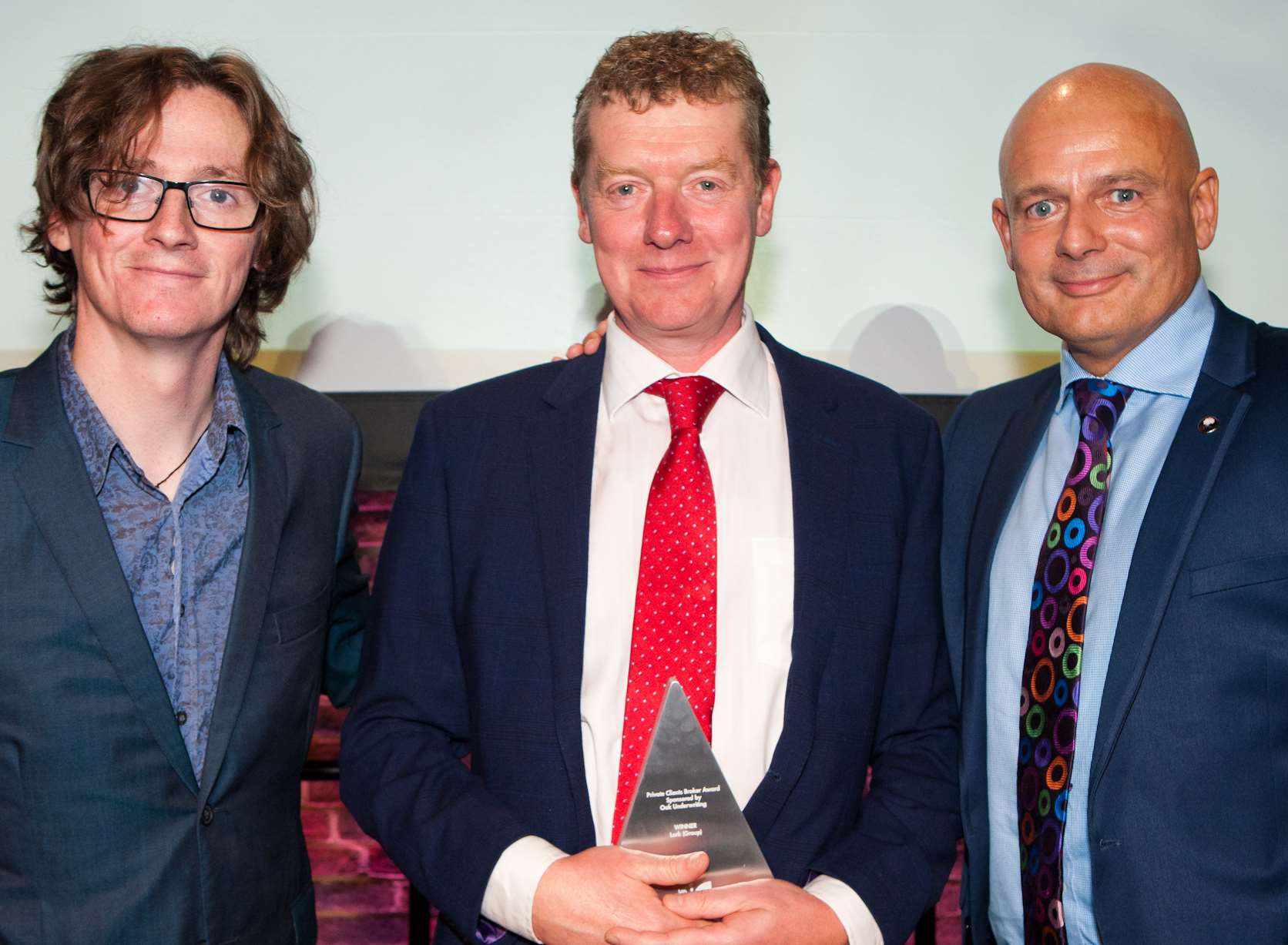 David Foster receives the award from comedian Ed Byrne, left, and Mark Coffey, right, MD Private Client inc Oak Underwriting