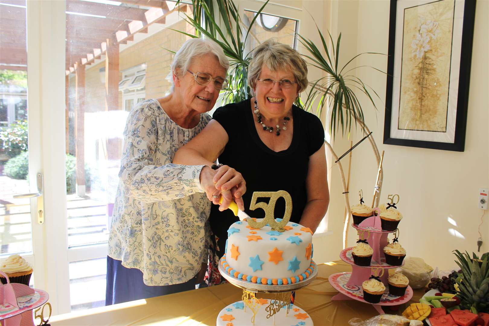 Founding trustees Christine Hughes and Janet Mann cut the cake to celebrate The Abbeyfield Kent Society's 50th year.