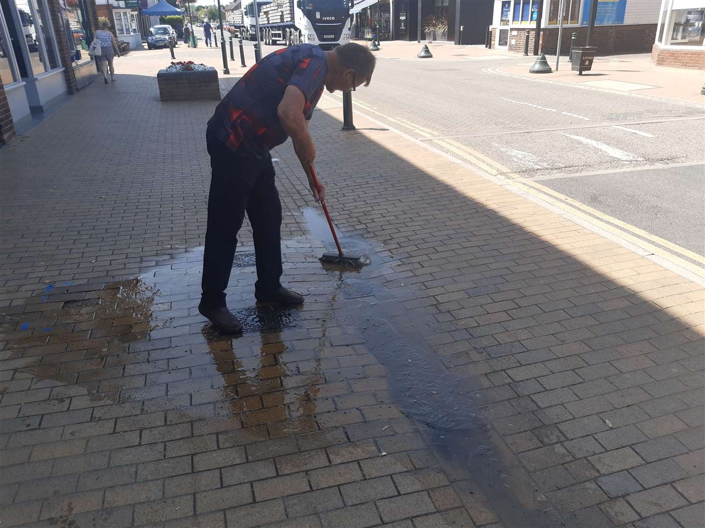 Ray Porritt sweeping away the water spill