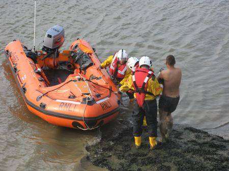 The man is helped into a boat by the RNLI