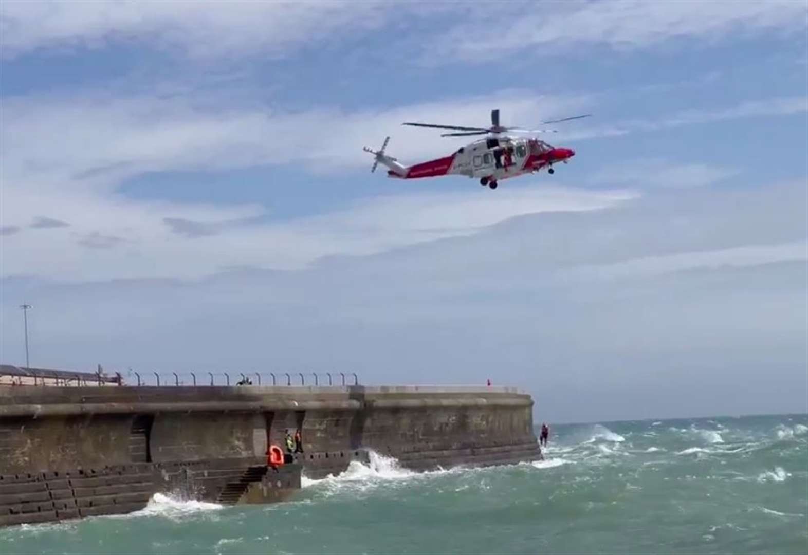 Dramatic moment two men in dinghy rescued from pier