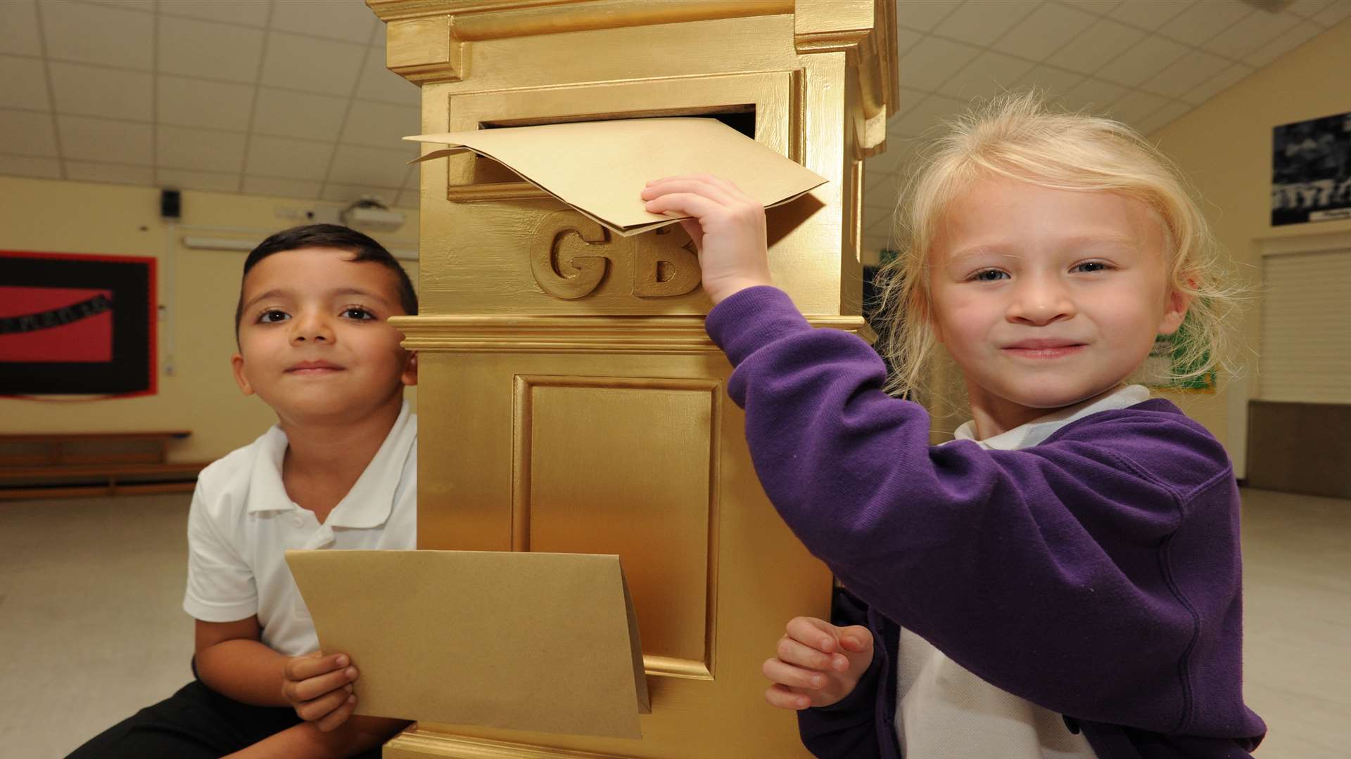 Harun and Kacey posting a letter in Holcombe HC's golden postbox