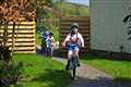 Three young siblings cycle marathon in garden to raise money for NHS