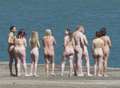 Cheeky models line up naked on beach for world-renowned artist