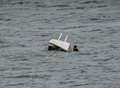 Sailors rescued after dinghy capsizes