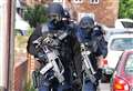 Armed police shut street and storm home
