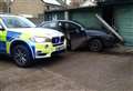 Driver arrested after car ploughs into garages 