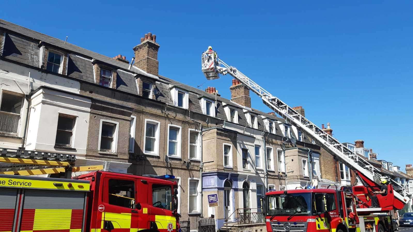 Firefighters use a ladder to access the roof