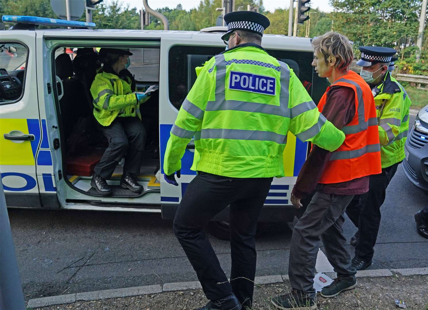 Officers lead a protester to a police van at a slip road at Junction 18 of the M25, near Rickmansworth (Steve Parsons/PA)