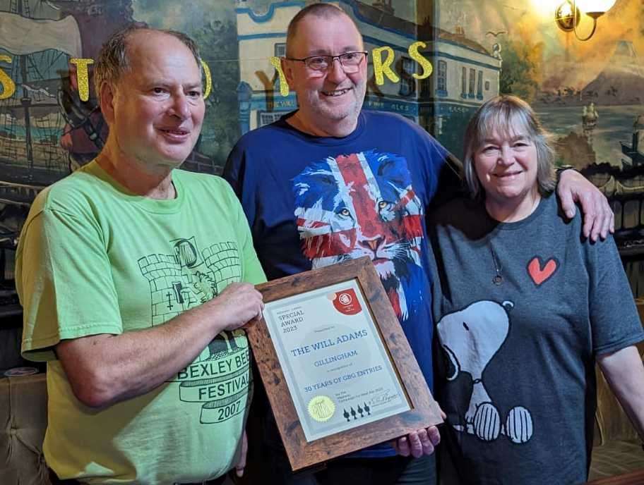 Tony Page from CAMRA (left) presents publicans Peter and Julie Lodge with their certificate