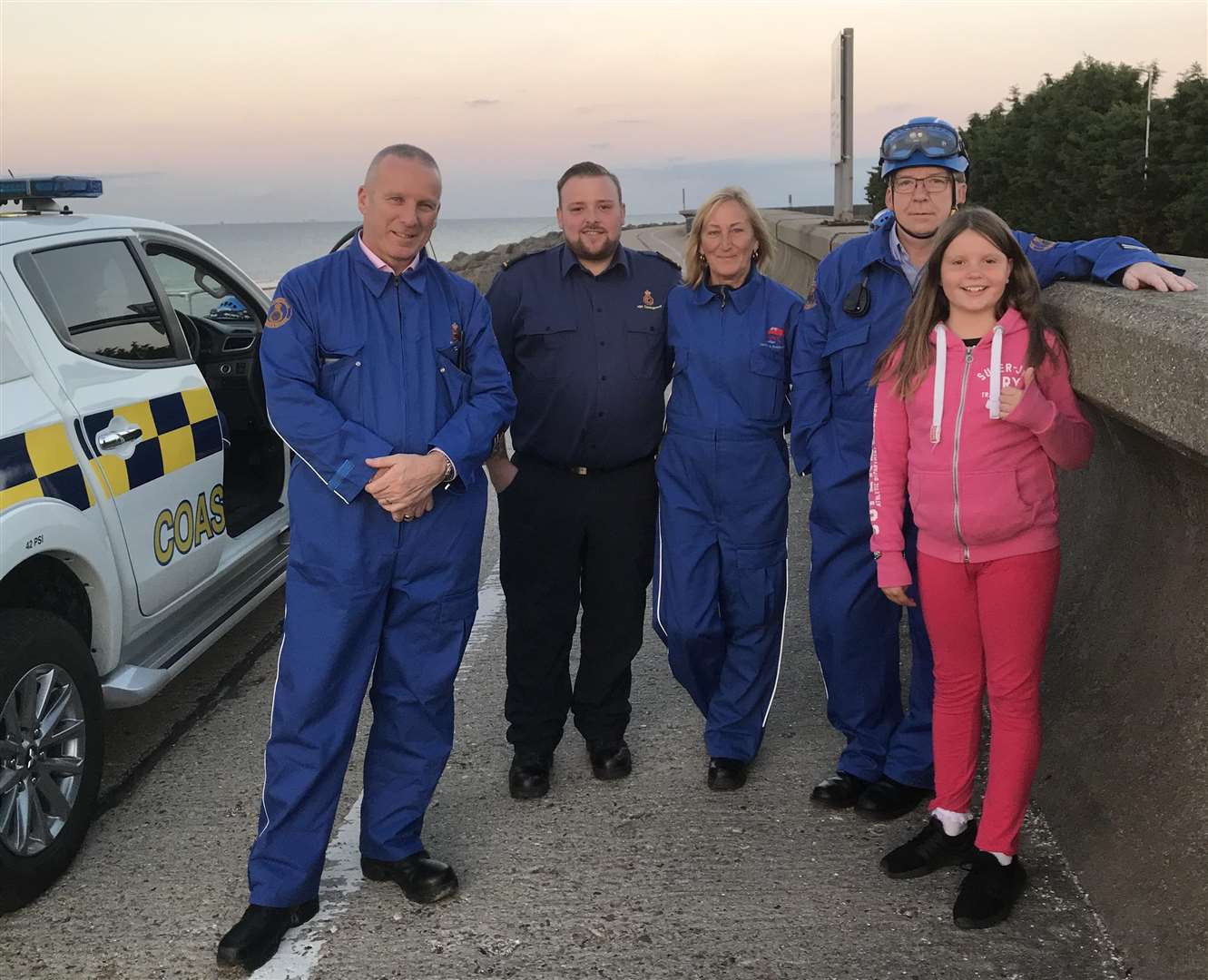 Isobel Osborne, nine, with coastguards and police officers after her find