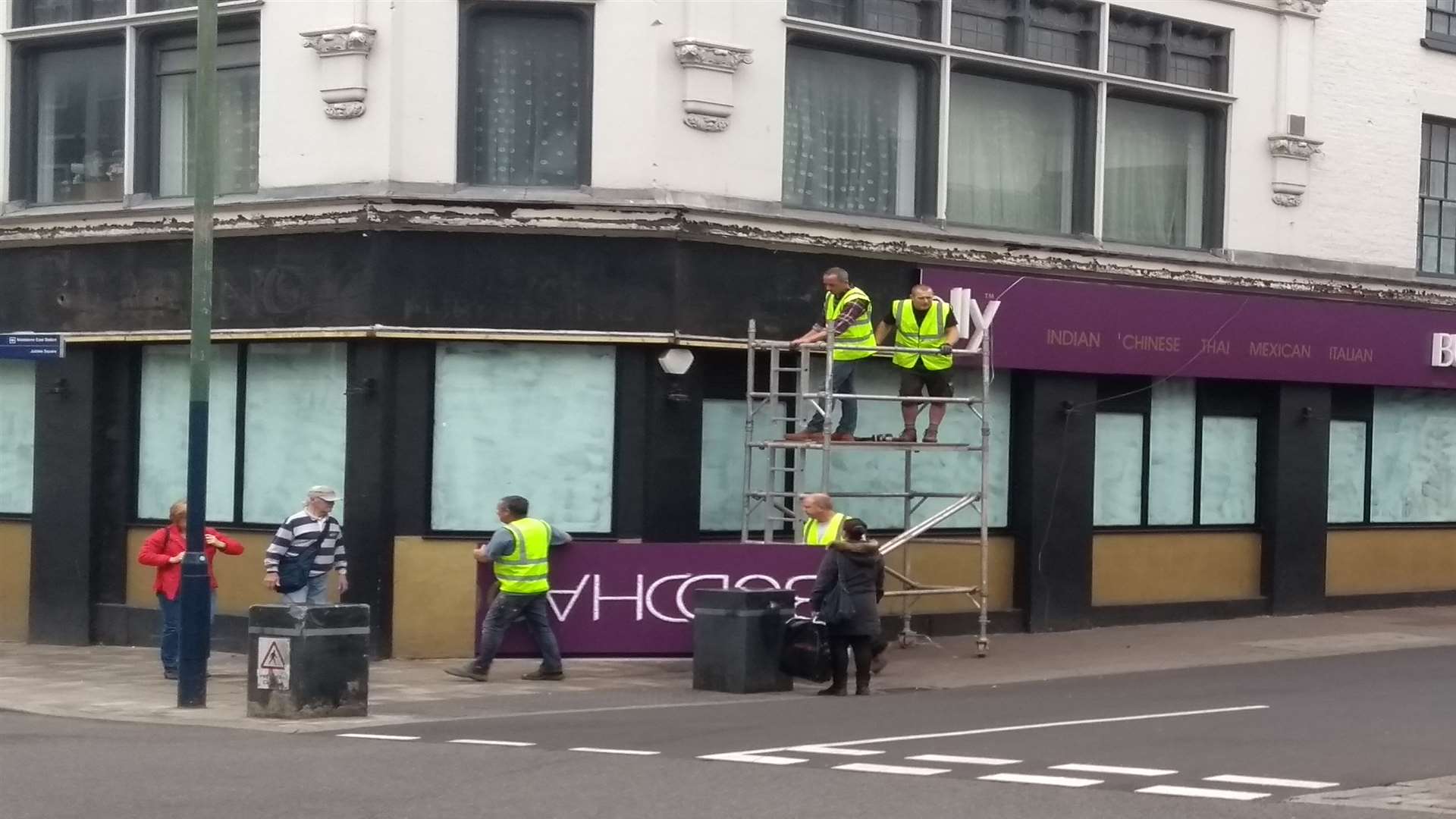 Workmen removing the sign at the restaurant