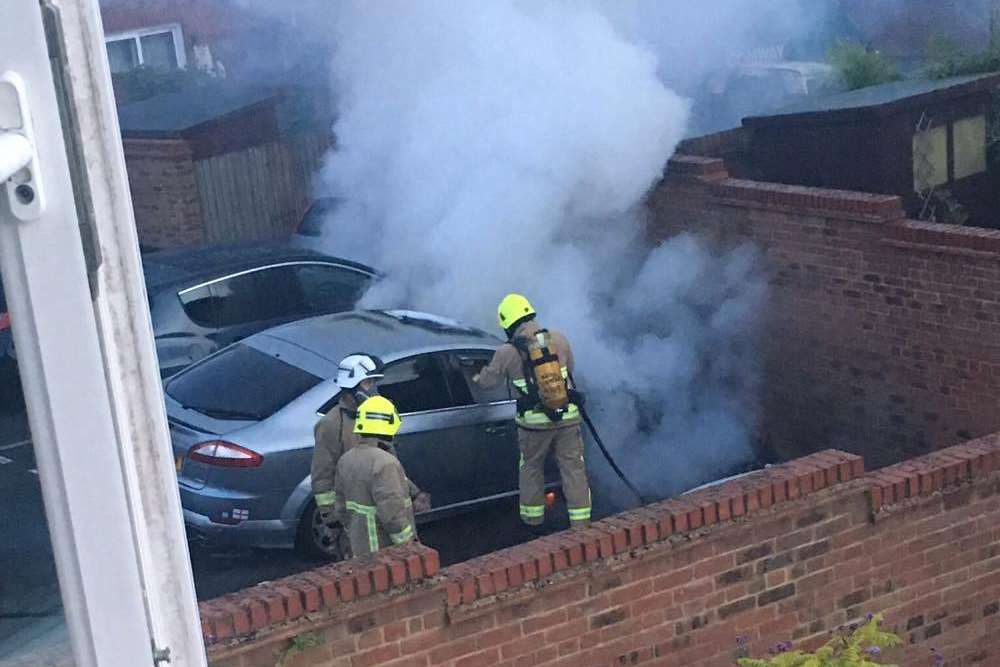 Fire crews doused the flames, which spread to a neighbouring car. Pic by Shannon Curtis.
