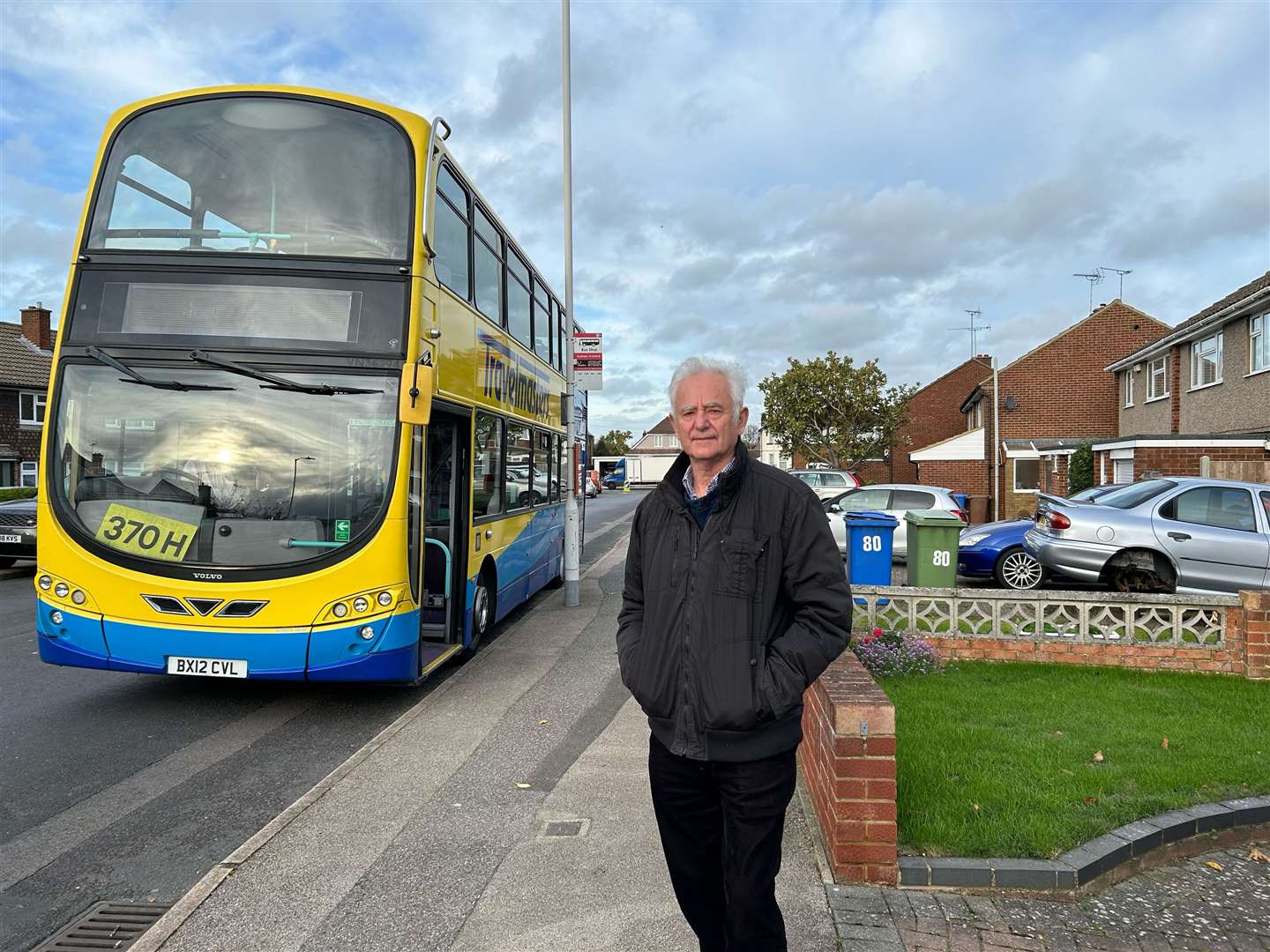 Cllr Roger Truelove standing in front of one of the parked school buses in Sittingbourne's Adelaide Drive