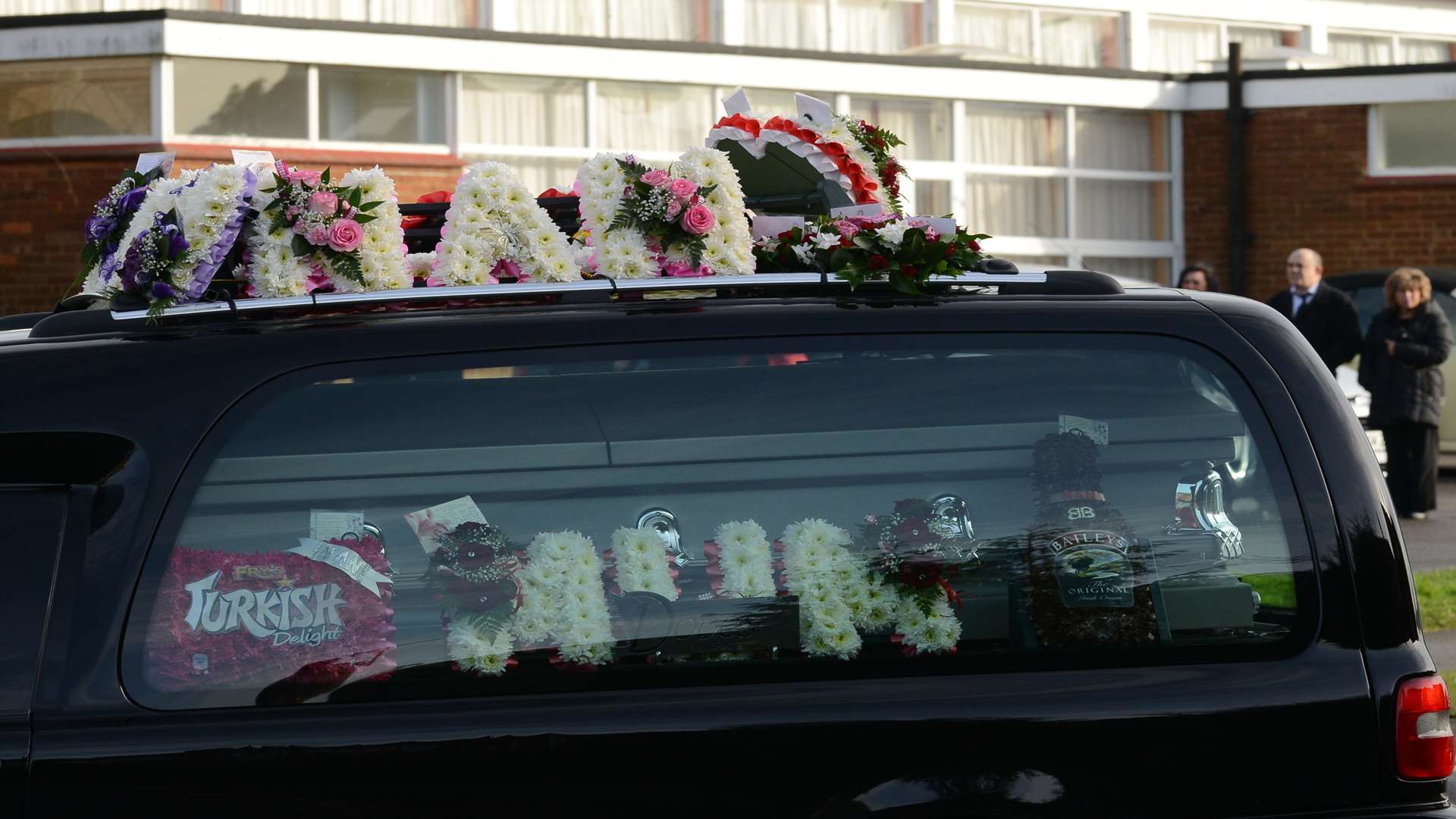 Colourful floral tributes read "Mum" and "Nan"