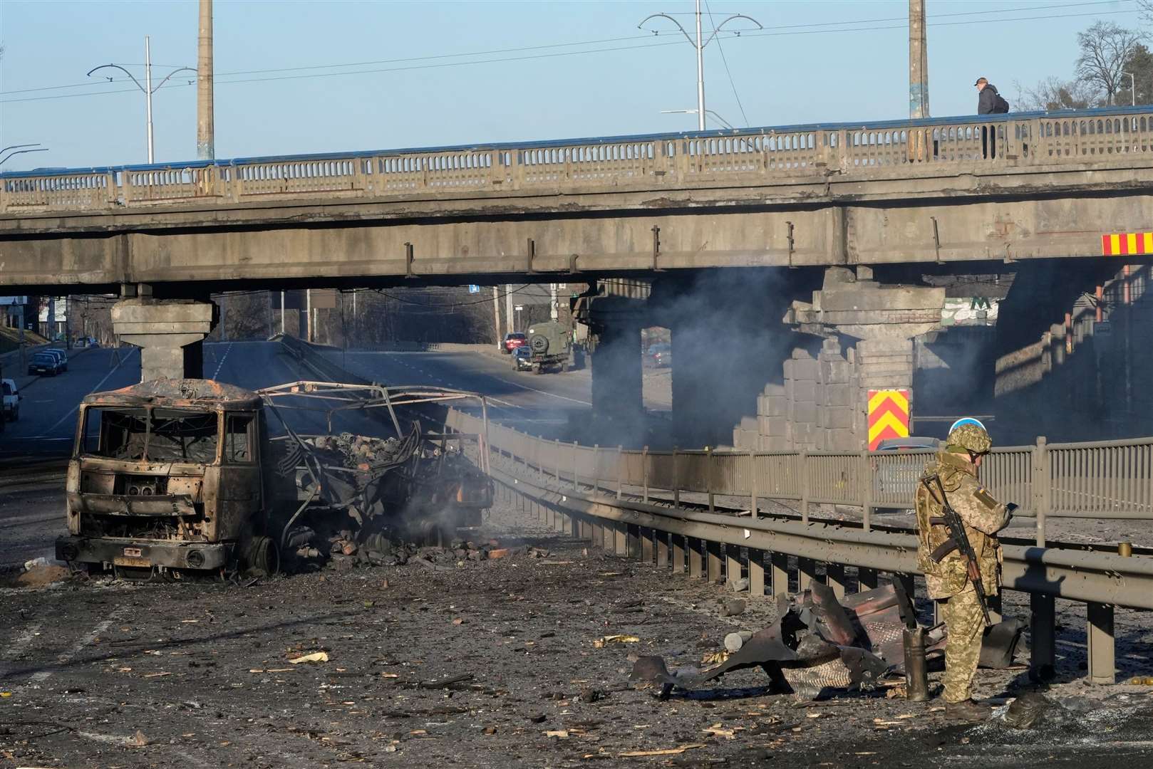A Ukrainian soldier investigates debris of a burnt military truck in a street in Kyiv. Picture: Efrem Lukatsky/AP