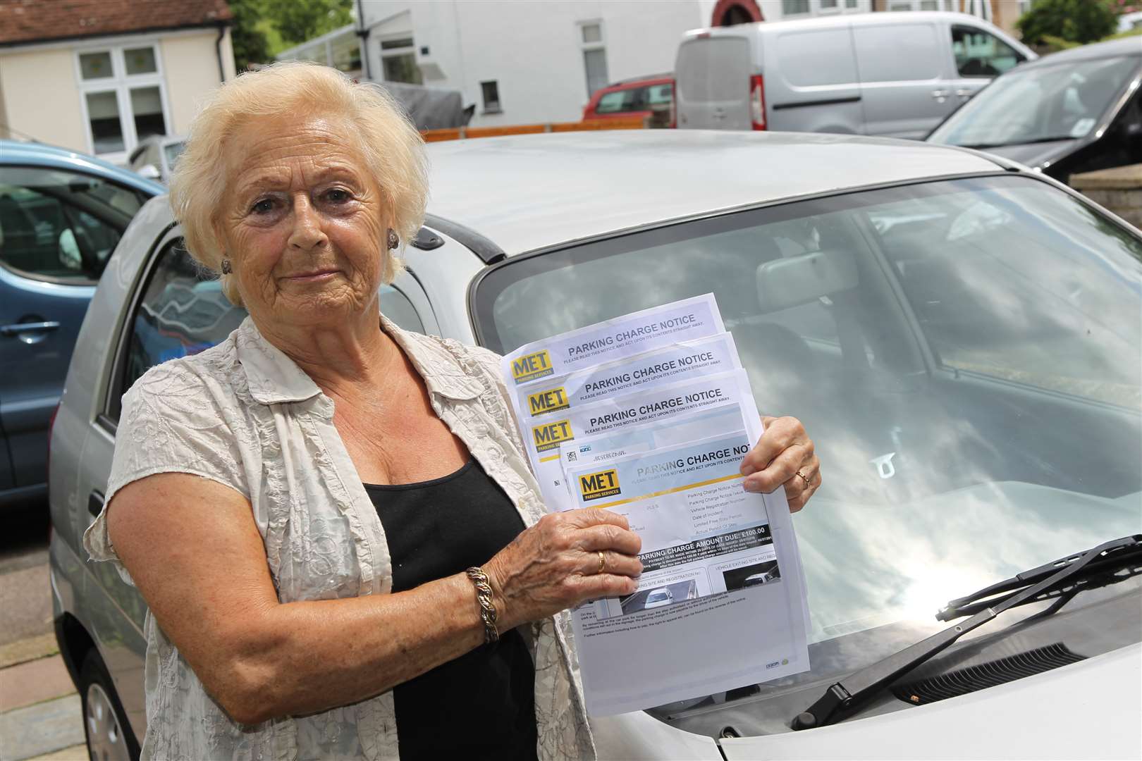 June Mace with four parking fines notices for £100 each, which she received after parking at Fairfield Leisure Centre.