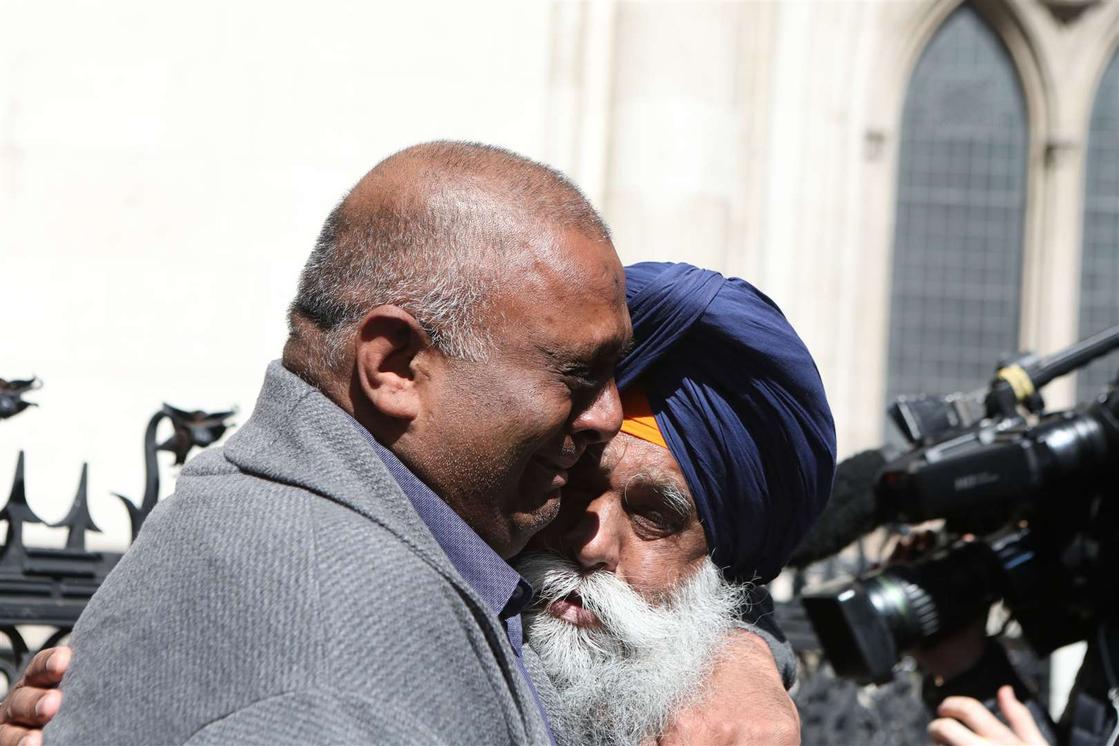 Former post office worker Harjinder Butoy (left) hugs his father after his conviction was overturned (Luciana Guerra/PA)