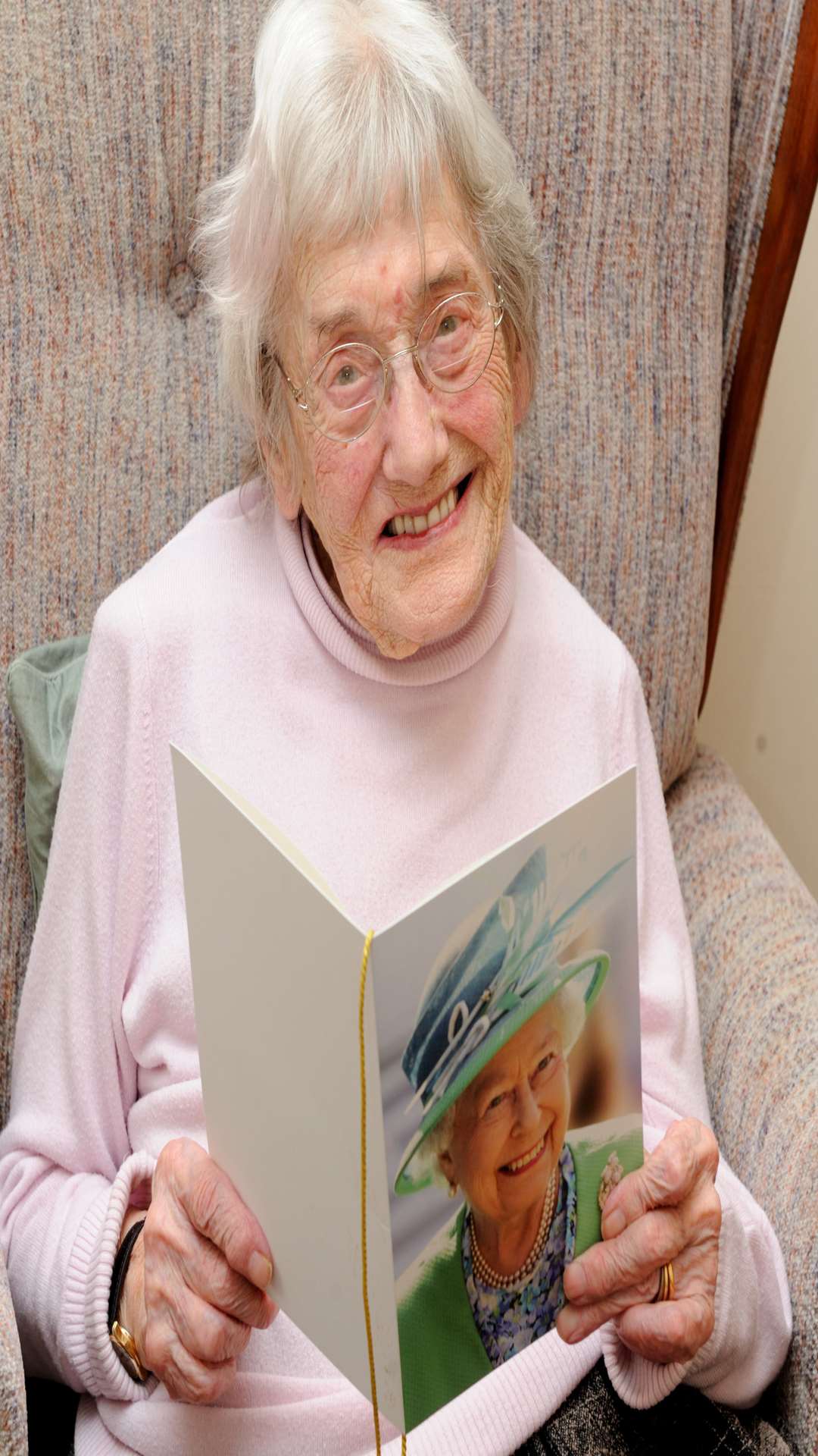 Jean Green holding her birthday card from the Queen in her room in Gardenia House residential home, Temple Hill