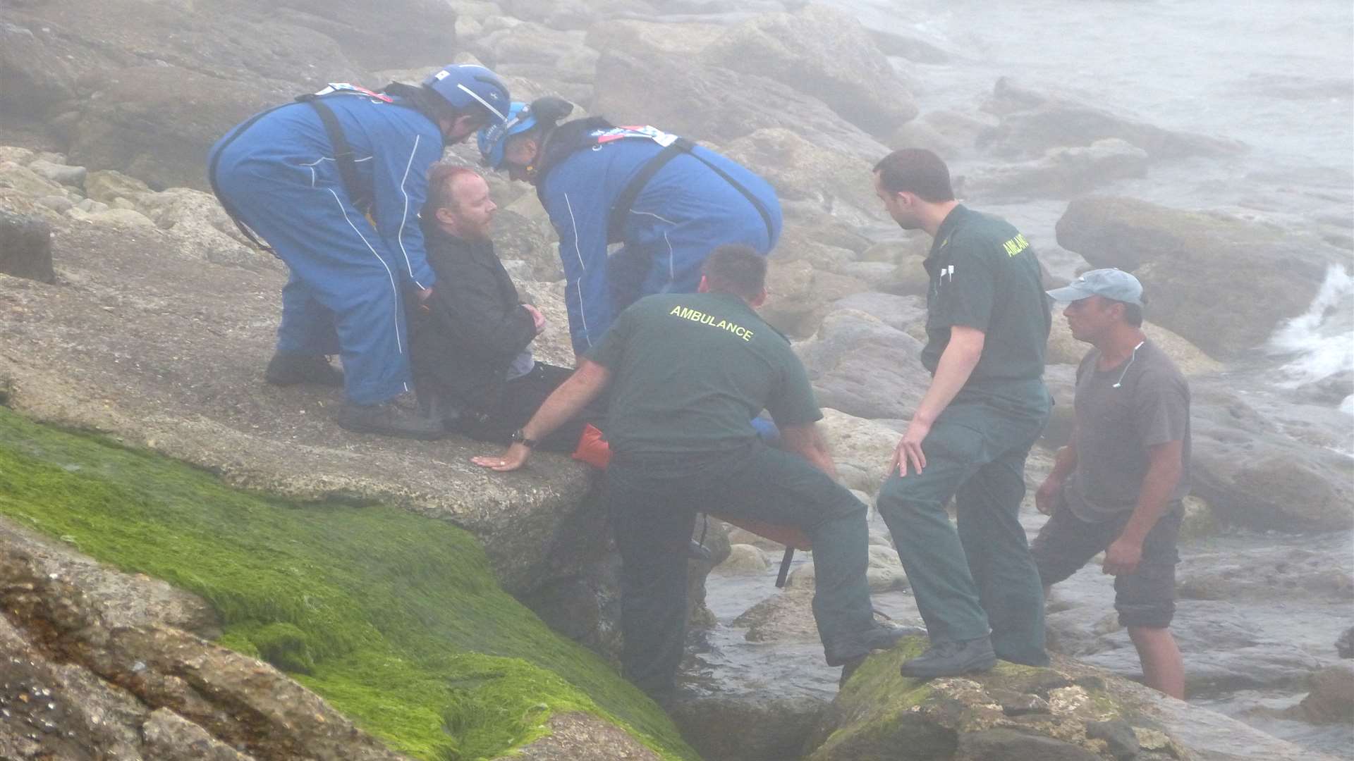 The man is helped from the rocks in the fog. Picture: @Kent_999s