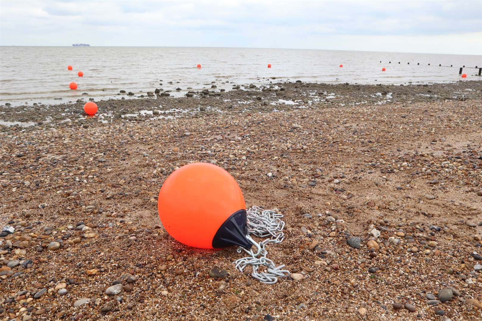 Part of Sheerness beach cleared of stones. Orange buoys mark the area at high tide