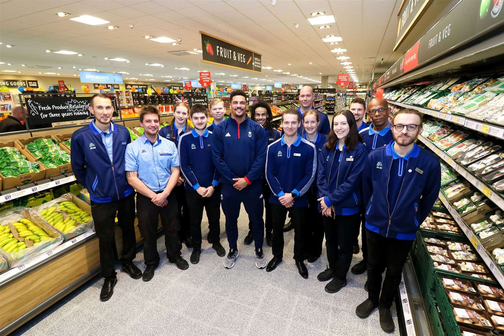 Matt Cook store manager, with Anthony Ogogo (centre) and Aldi Tunbridge Wells team in the fresh fruit and veg aisle