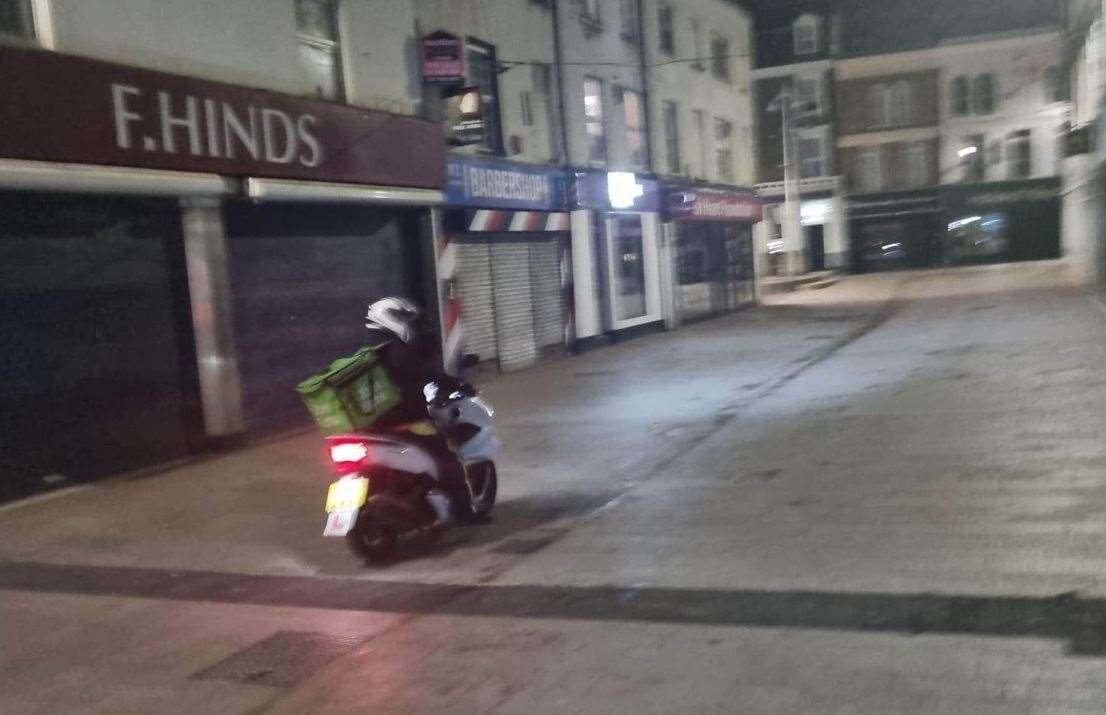 A takeaway rider speeds through a pedestrian-only section of Dartford High Street