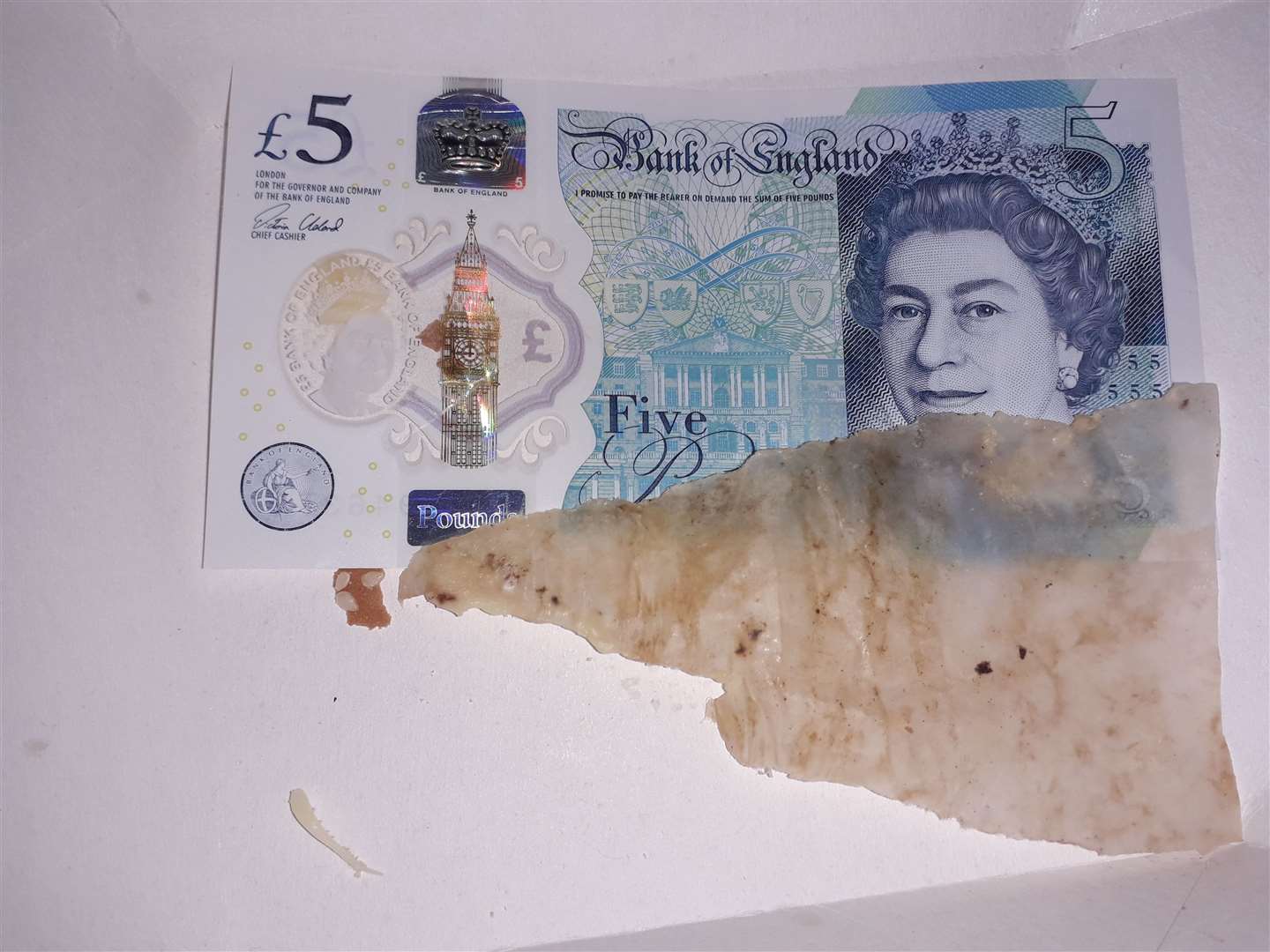 A £5 note alongside the rogue greaseproof paper, which somehow ended up in a Big Tasty with Bacon (9797353)