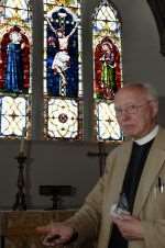 The Rev Brian Stevenson with the damaged stained glass windows at St Mary's Church, West Malling