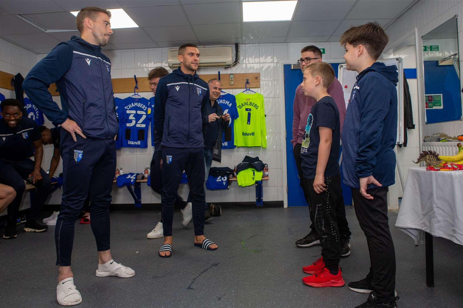 Ukrainian refugee Daniel Lysak (right) meets Gills players Olly Lee and Stuart O'Keefe before the game. Picture: KPI