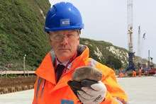 MP Charlie Elphicke with one of the rocks thrown down by yobs on the Dover railway line repair site at Shakespeare beach.