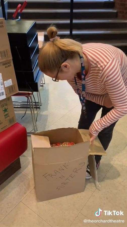 Orchard Theatre worker Kay opens the box to find 416 frankfurters inside. Photo: @Orchardtheatre
