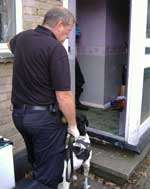 Officers enter one of the properties with sniffer dogs