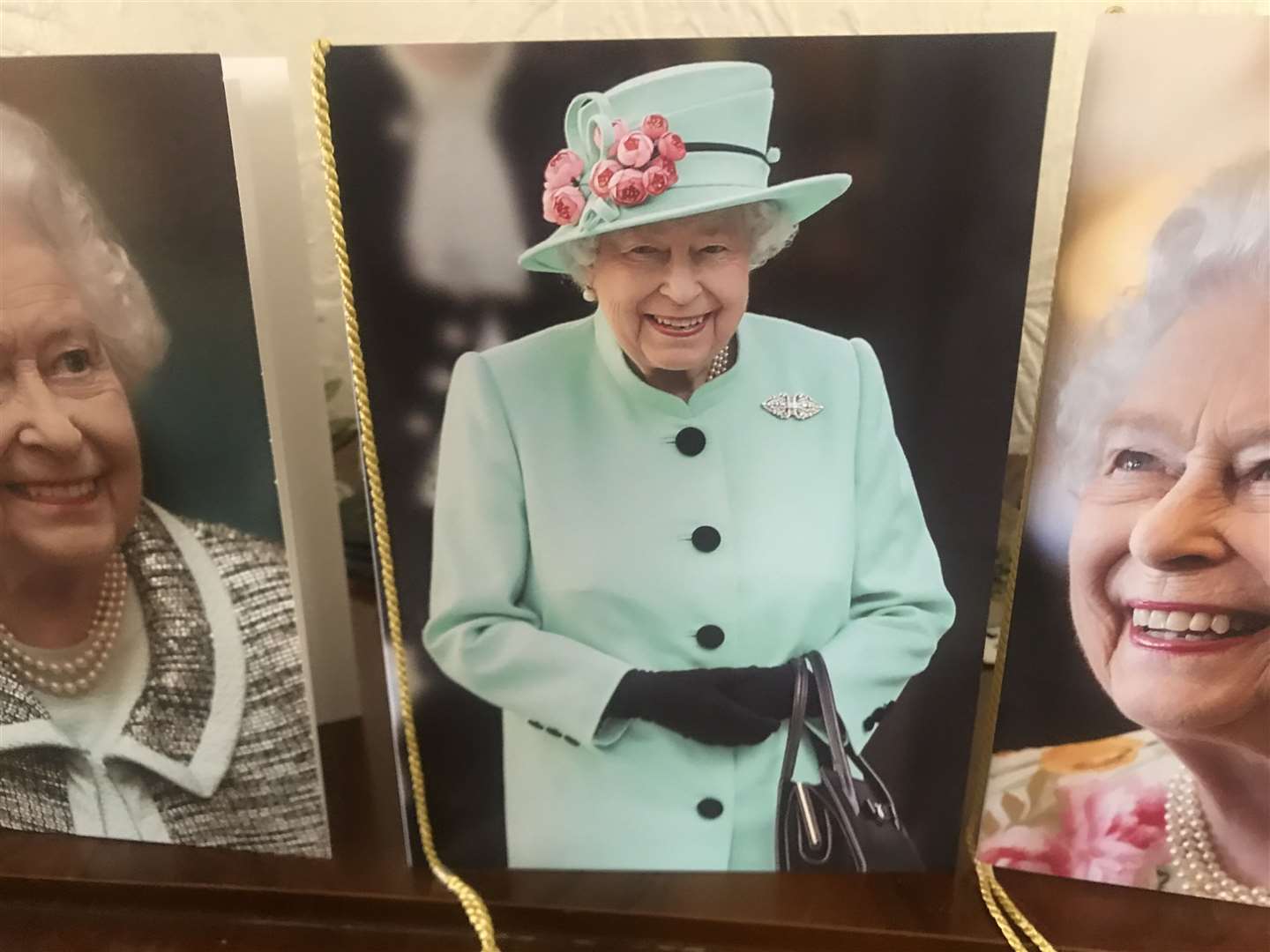 This year's card shows The Queen in a mint green coat and hat