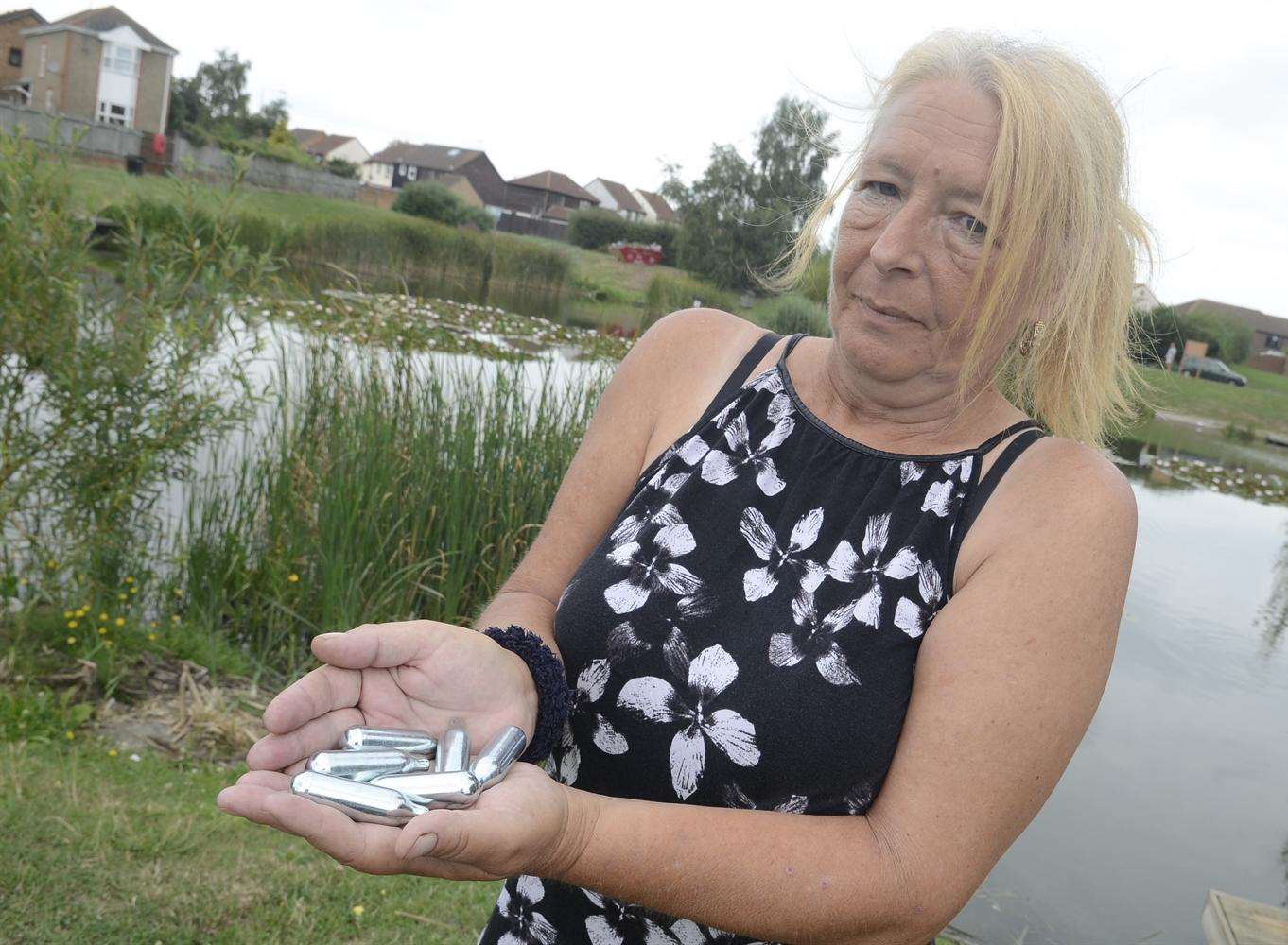 Karen Groombridge with gas gun canisters found around the lake near Newman Drive