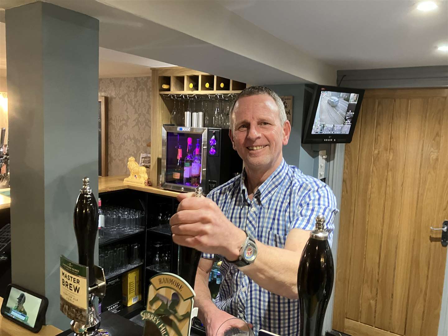 Manager Simon Banfield pours a pint at Marden Village Club